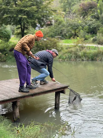 Vater und Sohn keschern am Steg einen Fisch